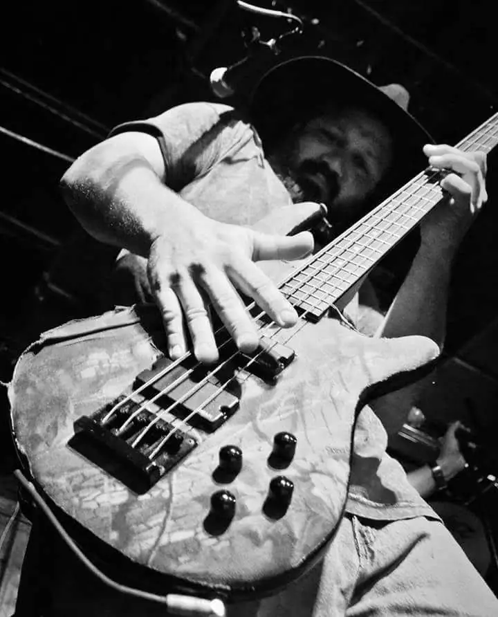 Black-and-white close-up of a bass guitar being played