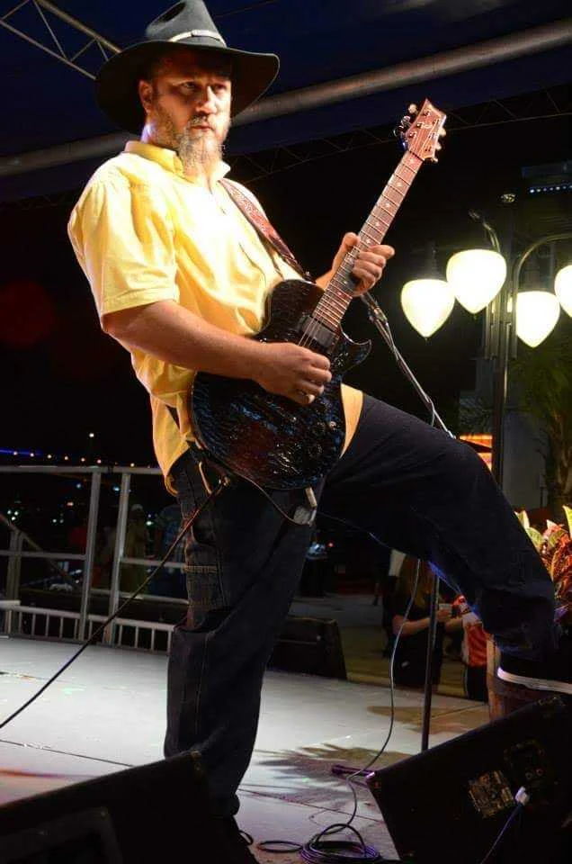 Guitarist in a cowboy hat performing on stage